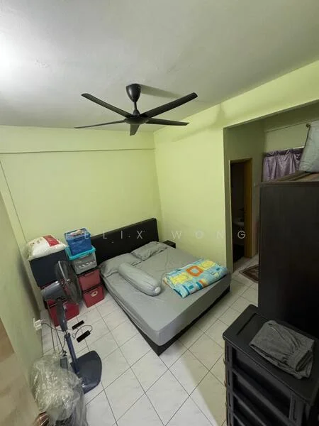 Bedroom features: queen-size bed, upholstered headboard, bedding with colorful pattern, ceiling fan, white tiled flooring, light green painted walls, built-in wardrobe, black dresser, plastic storage boxes, floor fan, window with curtain.