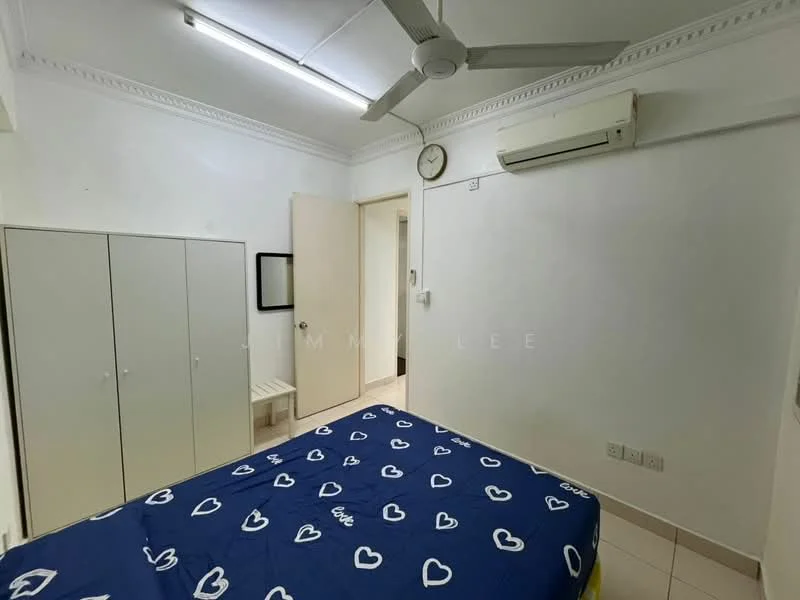 Bedroom features: white painted walls, ceiling fan, wall-mounted split AC, tile flooring, queen-size bed with blue heart-patterned bedding, built-in wardrobe with sliding doors, mirror on wall, clock on wall, door to hallway, small bench, light fixture on ceiling.