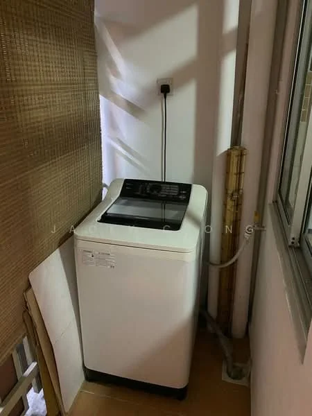 Laundry features: top-load washing machine, white appliance, power outlet, water supply hose, drainage pipe, tile flooring, window with natural light, bamboo curtain.