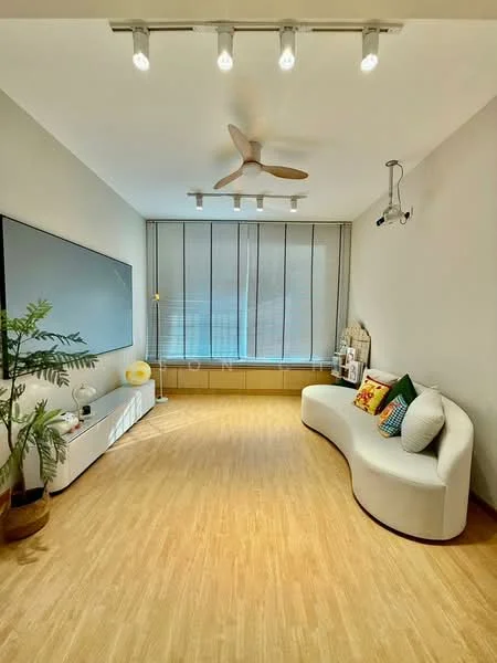 Living features: curved white sofa, decorative cushions, wooden flooring, wall-mounted TV, ceiling fan with light, recessed lighting, large windows with blinds, potted plant, white TV console, wooden window ledge; style: modern.