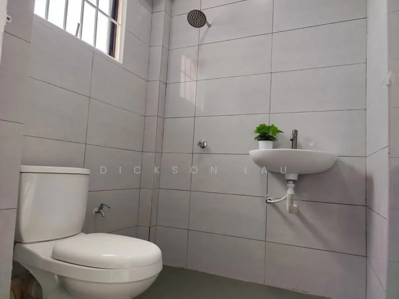 Bathroom features: white one-piece toilet, wall-mounted sink, chrome faucet, rain shower head, grey tiled walls, grey tiled flooring, small potted plant on sink, window for natural light; style: modern.
