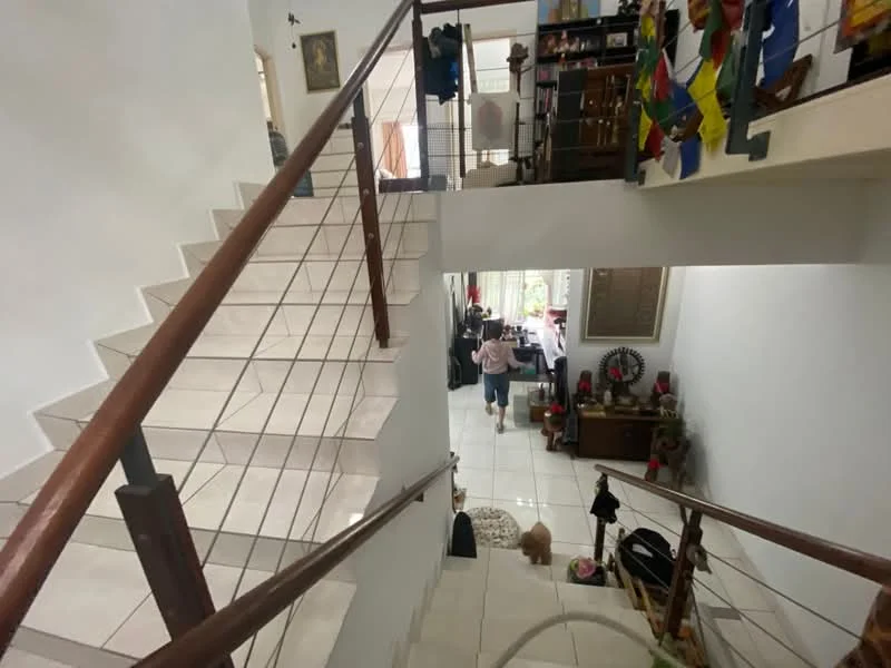 Room features: staircase with wooden railing, white painted walls, ceramic tile flooring, open space layout, decorative wall art, bookshelves, various decorative items, natural light from windows; style: modern; view: staircase.
