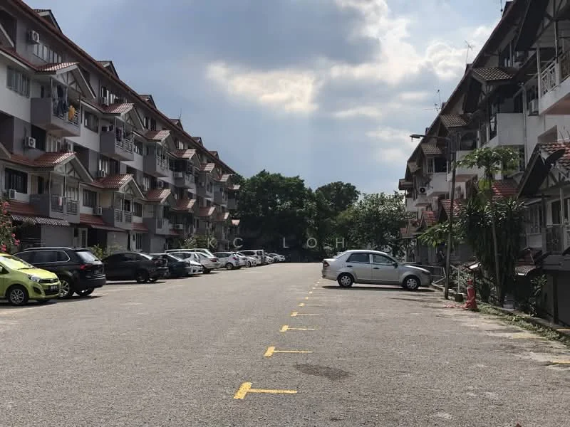 Exterior type: low-rise apartment block; features: 2-storey building, red tiled roof, white painted facade, balconies with railings, manicured landscaping, open-air parking lot, multiple parked cars, surrounded by greenery; style: modern.