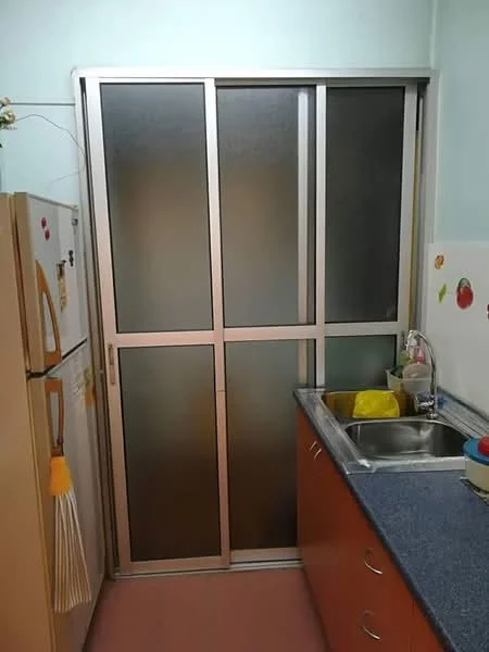 Kitchen features: double-bowl stainless-steel sink, chrome pull-down faucet, blue countertop, wood cabinetry with orange finish, refrigerator with yellow and white exterior, sliding glass door, wall-mounted decorations, pink tile flooring.