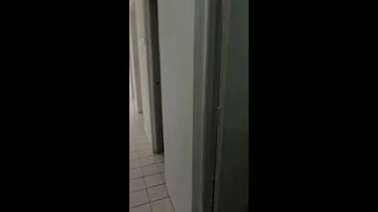 Room features: white painted walls, tile flooring, door frames, doorway, hallway, light switch.