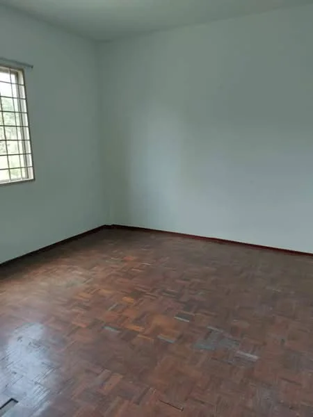 Room features: white painted walls, parquet wood flooring, single window with grid design, natural light from window.
