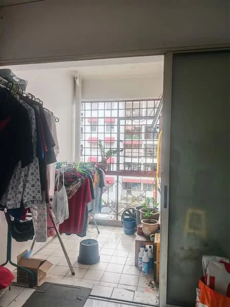 Laundry features: clothes rack with hanging clothes, tiled flooring, sliding glass door, window with grid pattern, potted plants, storage boxes, cleaning supplies, bucket; view: city.