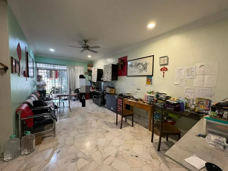 Living features: marble tile flooring, green painted walls, 5-blade ceiling fan with light, floor-to-ceiling windows, sheer curtains, dining table, wooden cabinets, multiple chairs, decorative wall art, cluttered workspace, wall-mounted clock, open layout, natural light from windows.