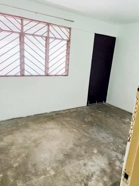 Room features: plain white walls, concrete flooring, large window with metal grille, doorway leading to another room.
