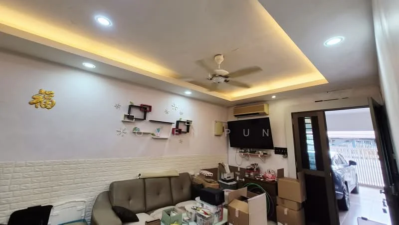 Living features: cream painted walls, exposed brick accent wall, tray ceiling with recessed lighting, 5-blade ceiling fan, wall-mounted TV, sofa in beige, coffee table, decorative wall shelves, air conditioning unit, various cardboard boxes, flooring not visible; style: modern.