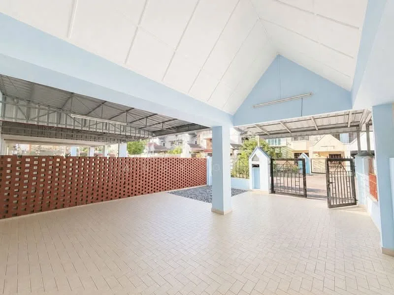 Exterior type: car porch; features: open-air car porch, paved flooring, blue painted walls, high ceiling, brick wall with ventilation openings, gated entrance, landscaped area with gravel, surrounded by residential buildings; style: modern.