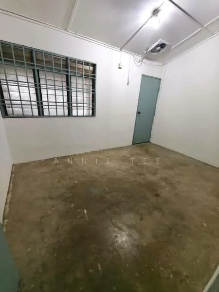 Room features: white painted walls, concrete flooring, single window with metal grille, door with green frame, ceiling with fluorescent lighting, wall-mounted air conditioning unit; style: minimalist.