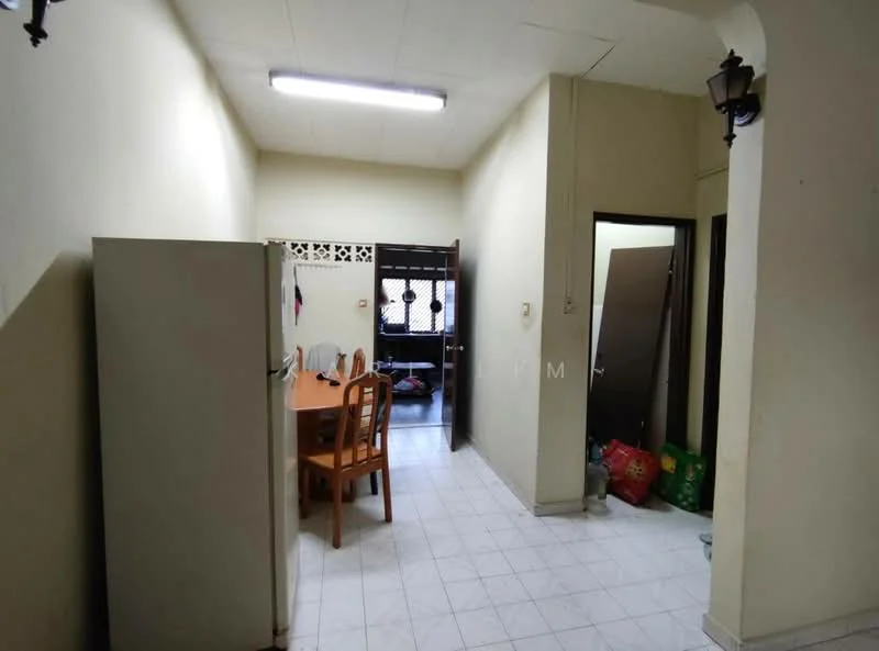 Room features: white painted walls, tile flooring, fluorescent ceiling lights, wooden dining table with chairs, refrigerator, door leading to outdoor area, door leading to another room, window with grille, plastic bags on the floor.