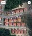 Exterior type: linked terrace house; features: red tiled roofs, paved roadways, surrounded by greenery, multiple units in a row, driveways visible, landscaped areas, open spaces between houses; style: modern.
