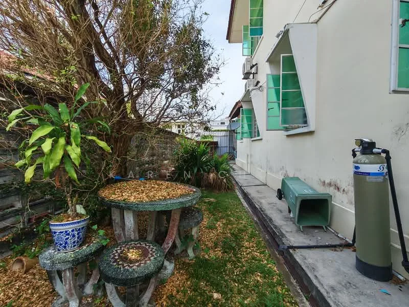 Exterior features: garden area, stone table with mosaic design, stone benches, overgrown plants, green windows, gas tank, concrete pathway, fence in background.