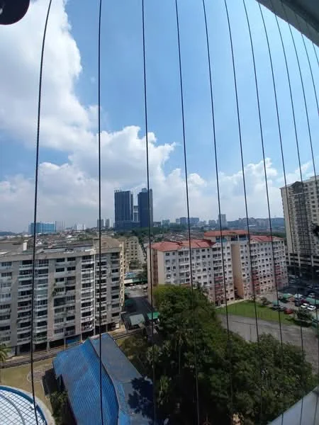Exterior type: high-rise condominium; features: city skyline view, surrounded by residential buildings, green landscaping, blue sky with clouds, balcony railing, multi-storey buildings in foreground; style: modern.