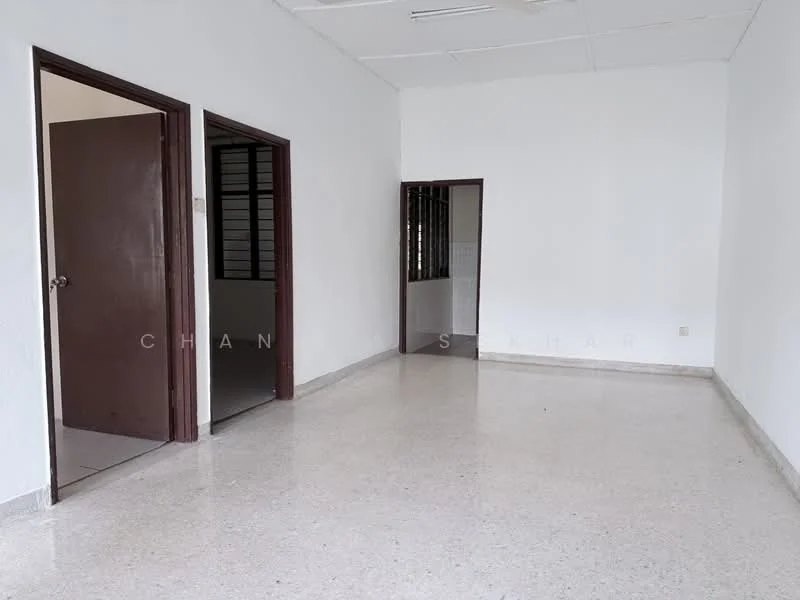 Room features: white painted walls, polished concrete flooring, drop ceiling, two wooden doors, one door leading to another room, one window with metal grilles, neutral color scheme, spacious layout; style: minimalist.