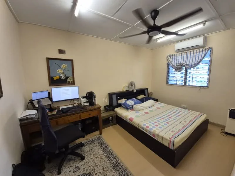 Bedroom features: queen-size bed with colorful polka dot bedding, wooden bed frame, study desk with computer monitor, black office chair, ceiling fan, window with horizontal blinds, wall-mounted air conditioning unit, framed artwork on wall, area rug with intricate pattern, wooden bedside table, wall-mounted light fixture.