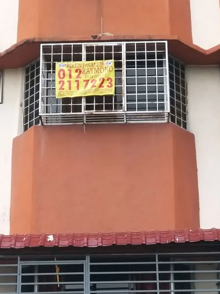Exterior features: orange painted facade, metal window grills, for sale sign, red roof overhang, two-storey building, corner unit.