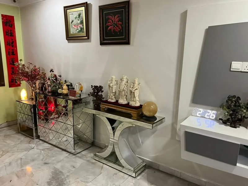 Room features: marble flooring, mirrored console table, decorative figurines, framed artwork, wall-mounted clock, decorative plants, table lamp, wall-mounted electrical outlets, red wall hanging, ornamental sculptures; style: modern.