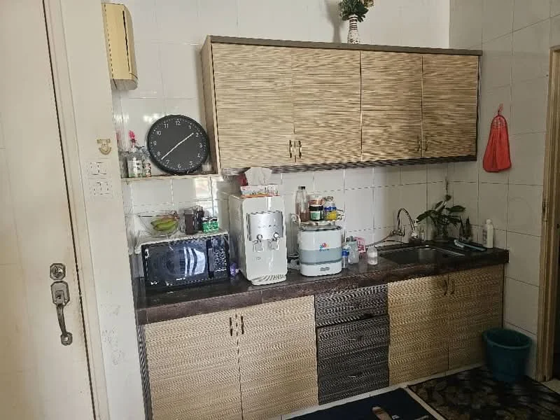 Kitchen features: wood cabinetry with woven texture, black countertop, stainless-steel sink, chrome faucet, microwave, water dispenser, wall clock, tile backsplash, decorative plant, flooring with patterned tiles; style: modern.