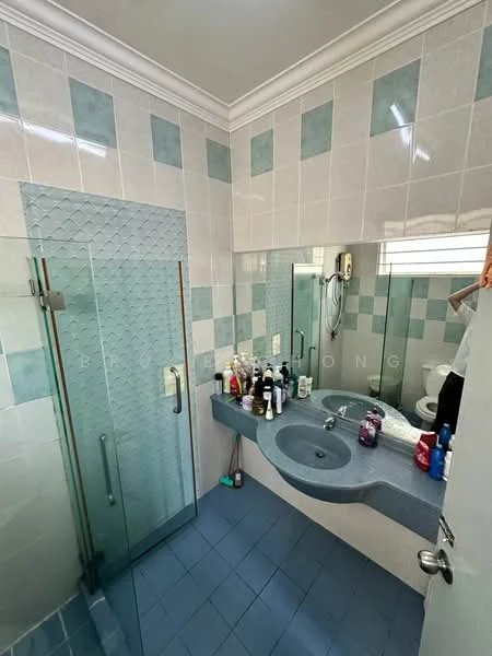 Bathroom features: glass shower enclosure, single-sink vanity with blue countertop, mirror above vanity, toilet, white tiled walls with blue accents, blue ceramic tile flooring, wall-mounted shower head, various toiletries on countertop.