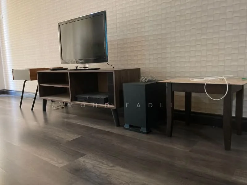 Living features: wooden flooring, textured wall with light color, flat-screen TV on console, wooden TV console with open shelving, small side table, black storage unit, cable management visible, minimalist decor; style: modern.