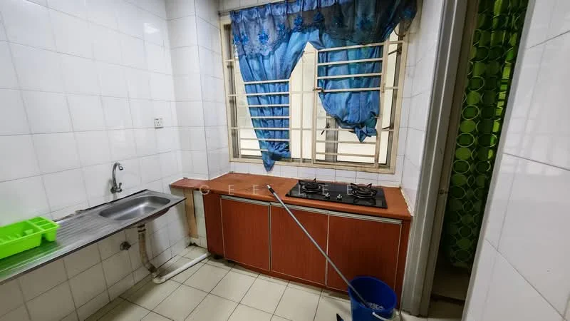 Kitchen features: single-bowl stainless-steel sink, chrome faucet, 2-burner gas hob, wooden countertop, white tiled walls, white tiled flooring, blue sheer curtains, green patterned wall, open window, cleaning bucket.