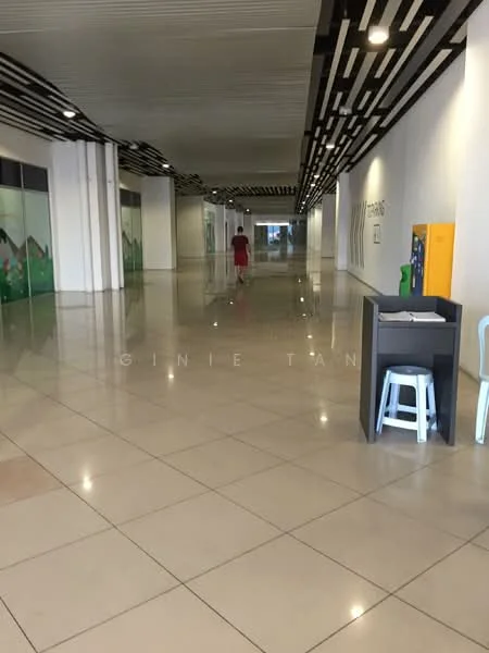 Room features: polished tile flooring, white painted walls, ceiling with linear wood paneling, large open corridor, brightly lit space, decorative wall murals, seating area with stool, information board, green landscaping elements on walls; style: modern.
