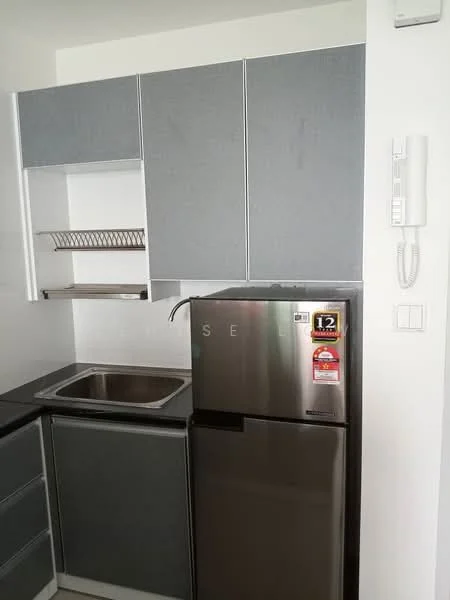 Kitchen features: grey cabinetry, stainless-steel sink, single-bowl stainless-steel sink, chrome faucet, black countertop, built-in shelving, stainless-steel fridge, wall-mounted intercom, white walls, tile backsplash; style: modern.