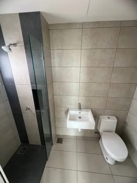 Bathroom features: walk-in shower with glass enclosure, rain shower head, wall-mounted faucet, white wall-mounted sink, one-piece toilet, grey tile flooring, beige wall tiles, drainage grate, glass partition, recessed lighting; style: modern.