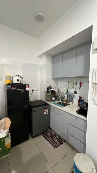 Kitchen features: grey cabinetry, white countertop, black fridge, silver fridge, stainless-steel sink, chrome pull-down faucet, wall-mounted shelves, ceramic tile flooring, white tiled walls, kitchen utensils, cooking pot, dish rack, kitchen mat; style: modern.