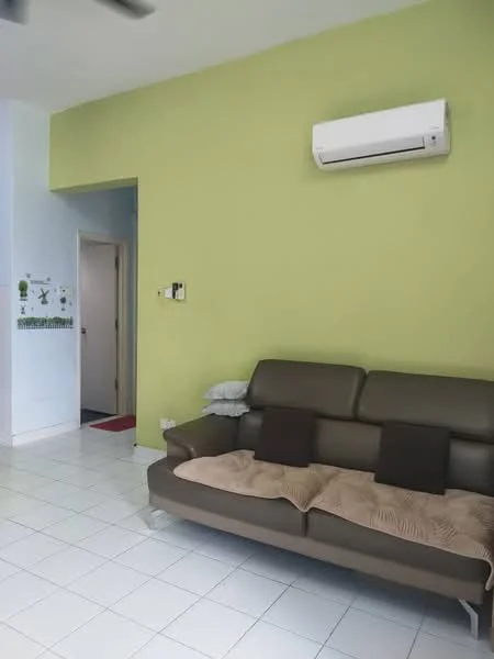 Living features: green painted wall, white tiled flooring, 3-seater leather sofa in brown, 2 decorative cushions in dark brown, wall-mounted air conditioning unit, doorway leading to another room, light-colored wall, blanket draped over the sofa; style: modern.