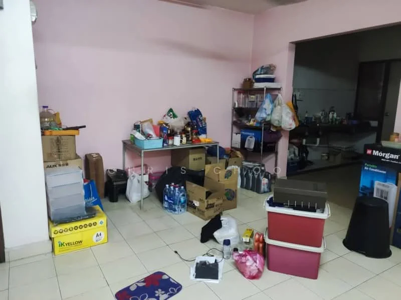 Room features: pink painted walls, white tiled flooring, various cardboard boxes, plastic storage containers, metal shelving unit, bottled water, plastic bags, miscellaneous household items, area rug with geometric pattern.