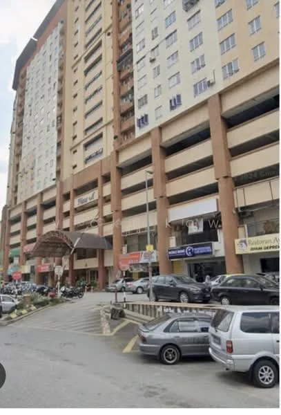 Exterior type: mid-rise condominium; features: multi-storey car park, commercial units at ground level, entrance with awning, balconies on upper floors, glass windows, cream painted facade, parking spaces visible, surrounded by urban context; style: modern.