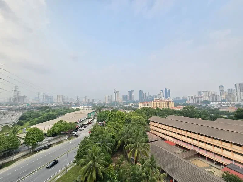Exterior features: city skyline view, surrounded by greenery, multiple high-rise buildings, low-rise buildings in foreground, road visible in foreground, power lines visible; style: modern.