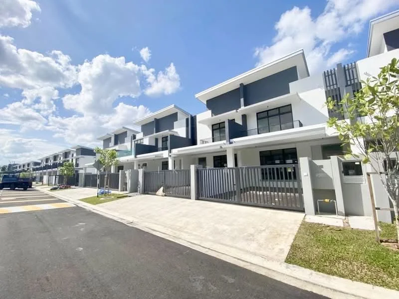 Exterior type: linked terrace house; features: grey and white painted facade, two-storey building, flat roof, recessed balconies, manicured lawn, paved driveway, fenced front yard, surrounded by mature greenery, multiple units in a row, clear blue sky, visible street with road markings; style: modern.