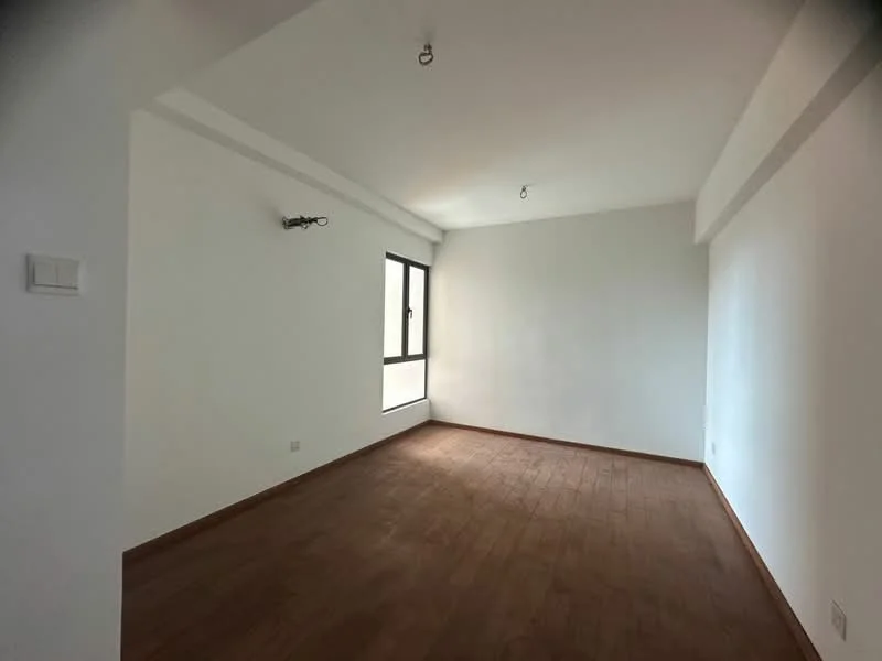 Room features: white painted walls, wooden flooring, single window, ceiling light fixture, no visible furniture, empty space; style: minimalist.