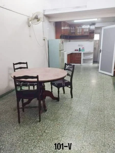 Dining features: round dining table, 4 wooden dining chairs, green speckled tile flooring, wall-mounted ceiling fan, white painted walls, wooden cabinetry, refrigerator, kitchen counter with sink, open layout to kitchen, natural light from window.