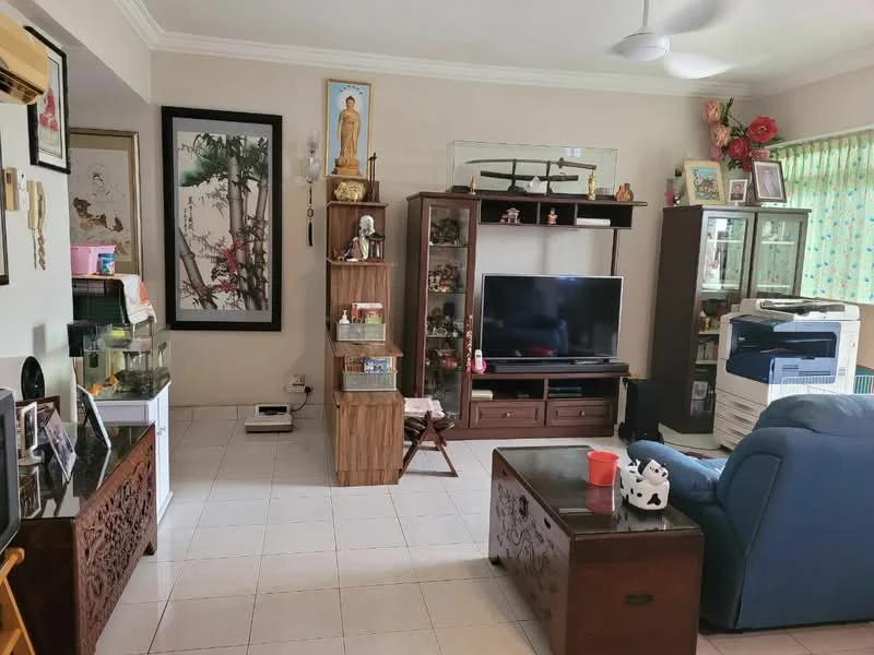 Living features: white painted walls, tiled flooring, 5-blade ceiling fan, large flat-screen TV, wooden TV console, glass display cabinet, wooden storage chest, blue fabric sofa, decorative wall art, green sheer curtains, wooden shelving unit, decorative plants, framed photographs; style: traditional.