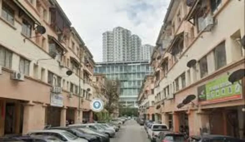 Exterior type: mid-rise condominium; features: multi-storey building, surrounded by low-rise buildings, parking spaces visible, balconies with railings, air conditioning units on walls, glass facade on upper floors, street view with vehicles, urban setting; style: modern.