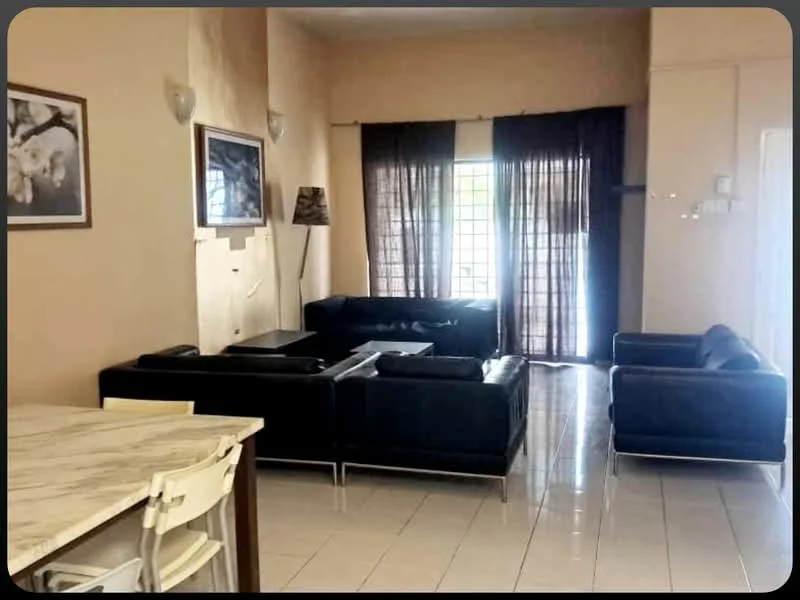 Living features: black leather sectional sofa, black leather armchair, coffee table, wall-mounted TV, framed artwork on wall, floor lamp, large windows with sheer curtains, white tiled flooring, cream painted walls, recessed lighting; style: modern.