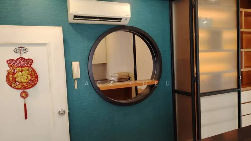 Room features: turquoise accent wall, circular mirror, wall-mounted split AC, white door, wooden cabinetry, glass-front upper cabinets, decorative wall hanging, neutral-colored countertop; style: modern.