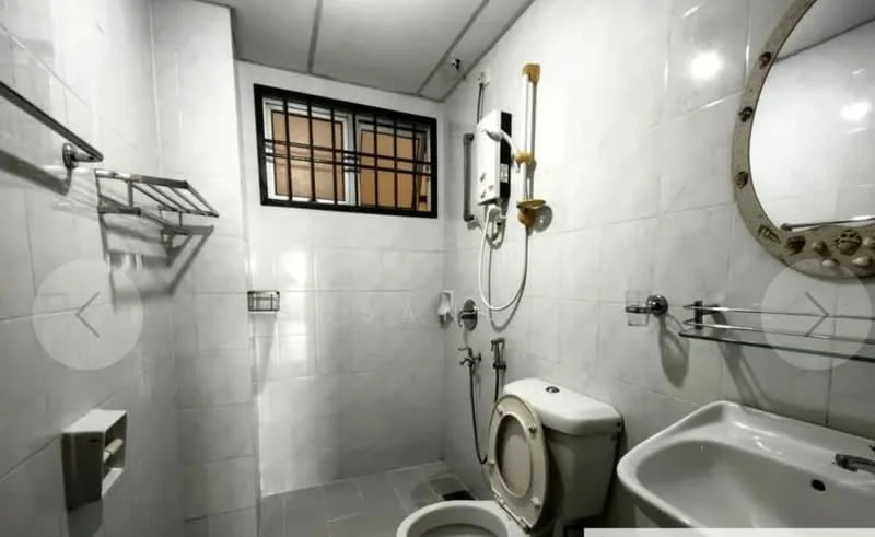 Bathroom features: white tiled walls, grey tiled flooring, round mirror, single-sink vanity, chrome basin mixer faucet, one-piece toilet, shower area with wall-mounted showerhead, water heater, towel rack, window with security bars; style: modern.
