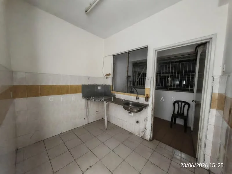 Room features: white painted walls, yellow tiled backsplash, grey sink, single-bowl stainless-steel sink, wall-mounted faucet, ceramic tile flooring, window with metal bars, doorway leading to another room, chair, fluorescent ceiling light.