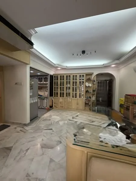 Room features: marble flooring, tray ceiling with recessed lighting, built-in cabinetry with glass doors, open layout, kitchen area visible, fridge, decorative items on shelves, neutral wall color, glass countertop, wooden accents; style: modern.