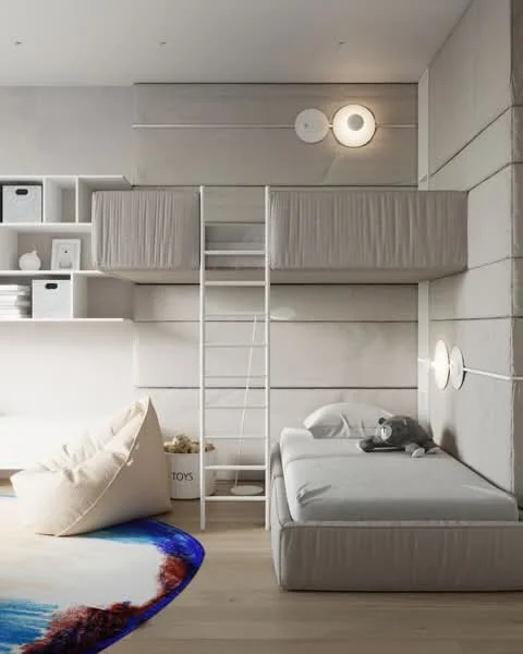 Bedroom features: bunk bed with soft grey bedding, single bed with soft grey bedding, bean bag chair, white shelving unit, decorative storage boxes, wall-mounted reading lights, light wooden flooring, textured grey walls, colorful area rug with abstract design, stuffed animal on bed; style: modern.