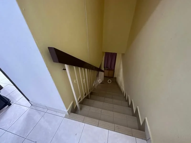 Room features: staircase with wooden handrail, tiled flooring, yellow painted walls, light source from upper level, doorway at the bottom of the stairs, curtains visible in doorway.