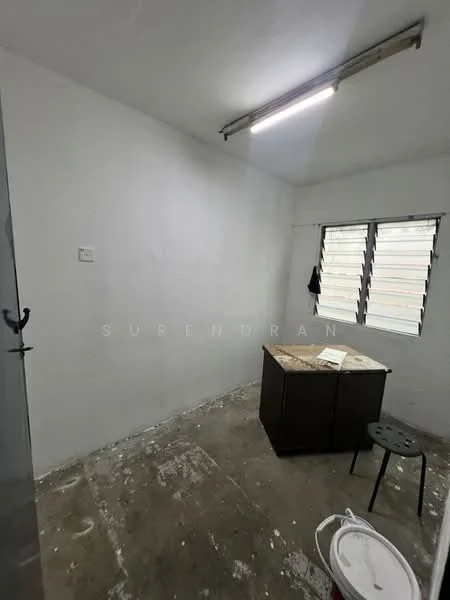 Room features: white painted walls, concrete flooring, single window with horizontal slats, overhead fluorescent lighting, unfurnished, empty room, no visible decor, basic electrical outlet; style: minimalist.