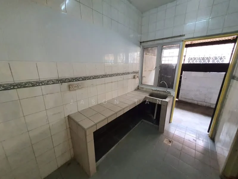 Kitchen features: white tiled walls, grey tiled flooring, single-bowl sink, window with metal grille, countertop with built-in cabinetry, wall-mounted electrical outlet, decorative tile border, door leading outside.